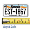 Nebraska License Plate Magnet displayed with a measuring tape for size reference.