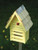 Handcrafted ladybug house with copper roof accent, designed as a decorative garden piece that supports beneficial insects and adds charm to outdoor spaces.