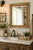 Farmhouse vanity mirror handcrafted from reclaimed barnwood with rich alder accents and rustic barbed wire details.