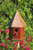 Handmade songbird birdhouse featuring rustic wood craftsmanship and elegant copper top design. Bright copper roof.