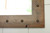 Rustic farmhouse mirror with warm alder wood tones and western inspired metal tack detailing