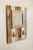 Rustic mirror with hooks displayed in an entryway, providing both a reflective surface and convenient storage for daily essentials.