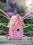 Close-up of colorful handcrafted birdhouse showing painted wood details and rustic outdoor finish