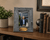 Custom retirement picture frame with engraved plaque displayed on an office shelf. Handcrafted reclaimed wood frame celebrating 35 years of service with a personalized retirement photo and message.