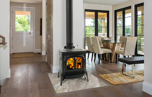 Black Intrepid wood stove with traditional doors in an entry way/dining room