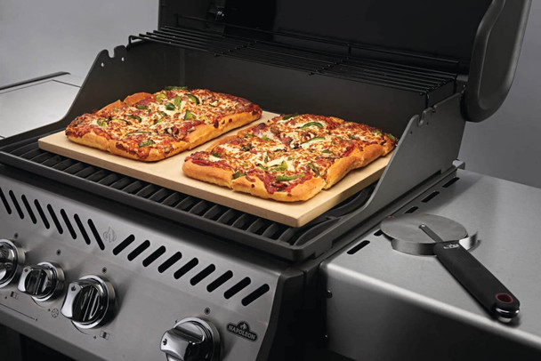 pizza on a stone cooking on a grill