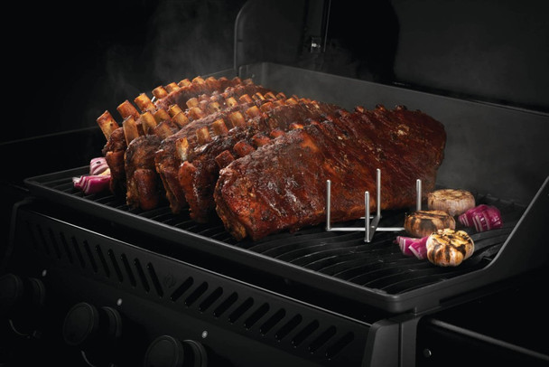 ribs cooking on a grill with the rib holder