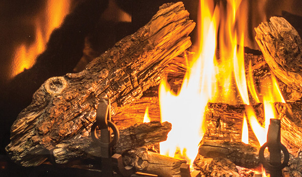 traditional log set and andirons burning