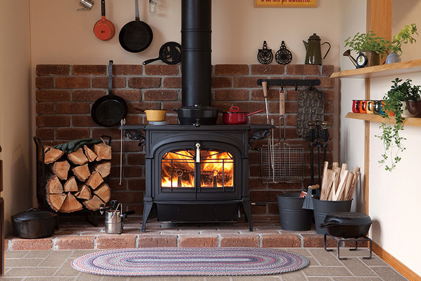 Encore stove in the middle of a brick hearth with stove accessories