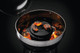 Dutch oven cooking in kettle with coals on top