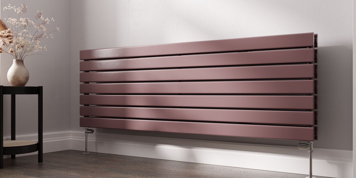 Dusty rose horizontal panel radiator, colour-matched to the room, on a bedroom wall