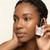 Woman applying Renewal In Bloom botanical eye serum under eyes