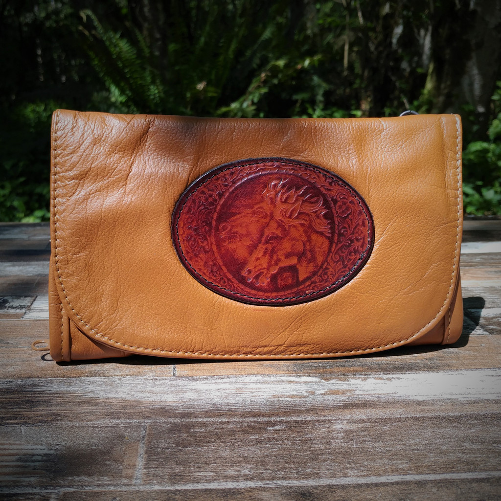 Cognac Strapped Wallet with Tooled Double Horse Head Medallion.

Combines the elegant look and quality of soft leather with a Tooled Leather Medallion on the front flap.