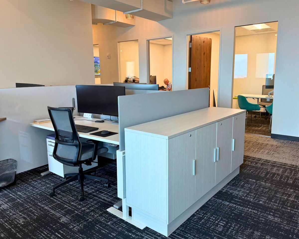 Workstation with ergonomic task chair, panel dividers, and storage credenza near private offices