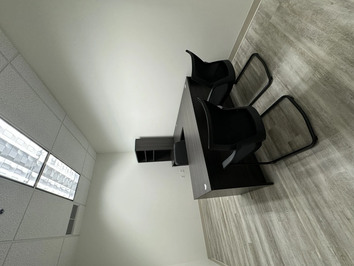 Compact private office with L-shaped desk, task chair, and two cantilever guest chairs