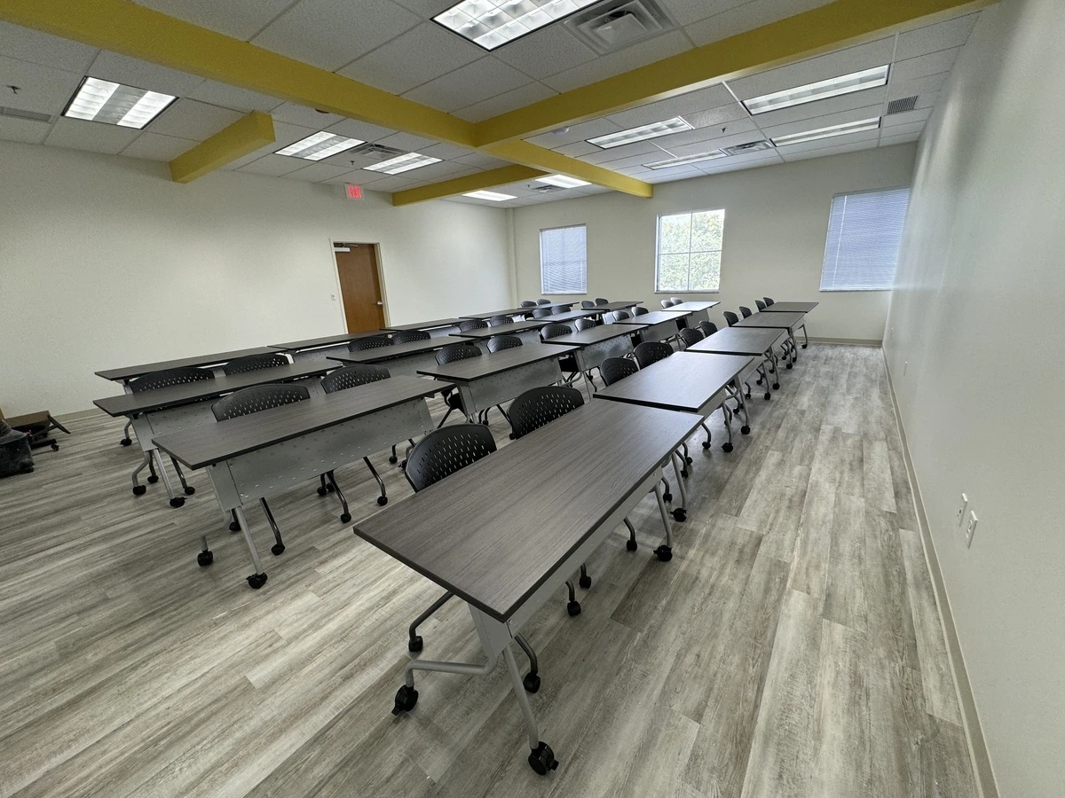 Classroom-style training room layout with charcoal tables and black chairs