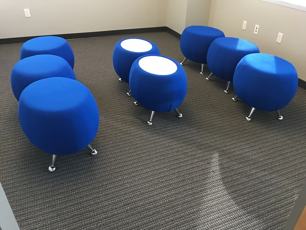 Blue upholstered ottomans with chrome legs and two white-top ottoman tables