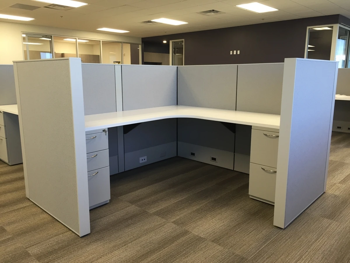 Open office workstation with high panels and corner desk near glass-front offices