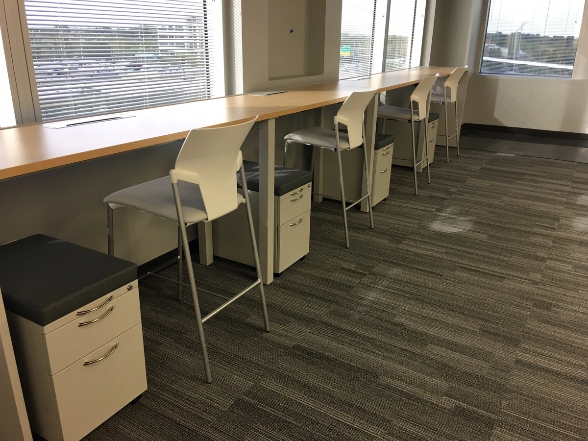 Window-side counter with white bar stools and mobile pedestals