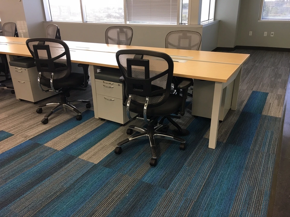 Bench-style desks with ergonomic mesh task chairs and mobile pedestal storage