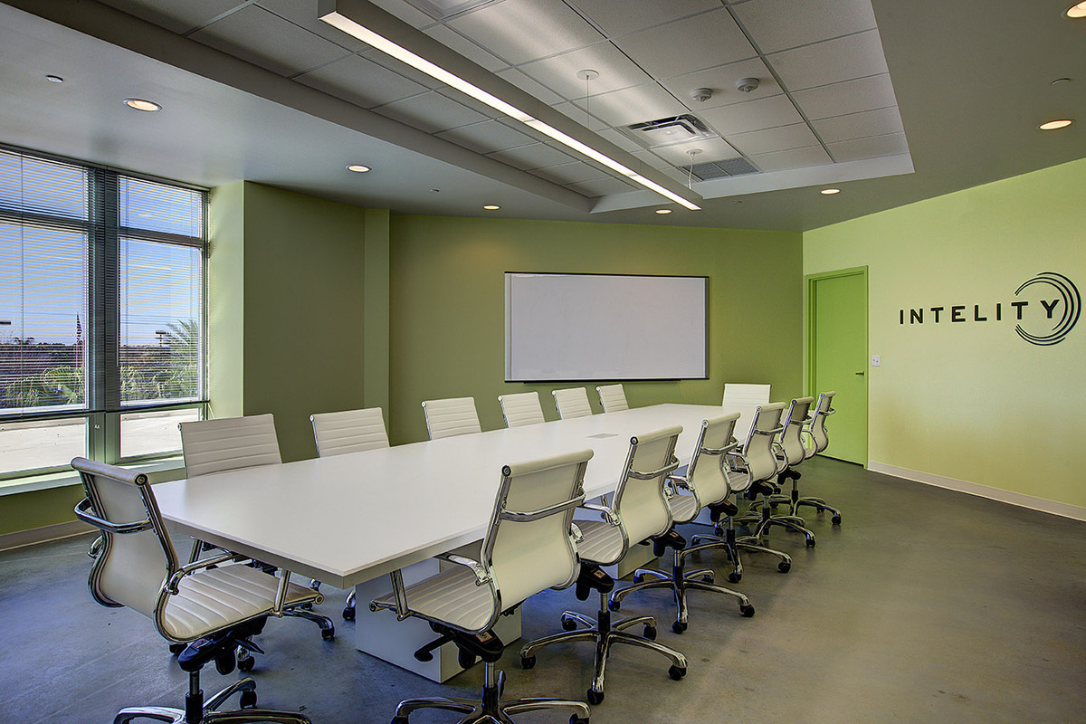 Intelity conference room with long white table, white ribbed chairs, and whiteboard, Orlando