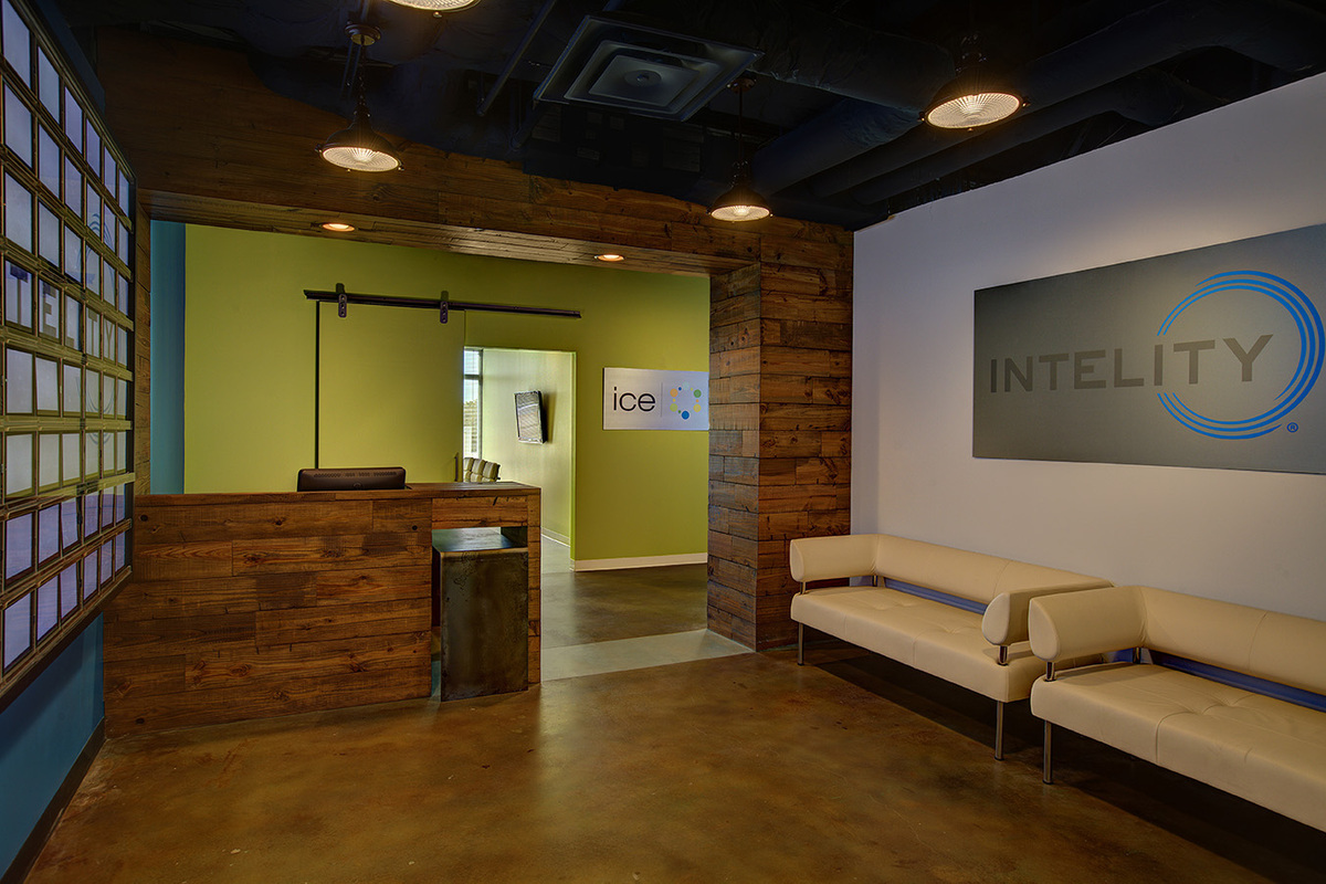 Reclaimed wood reception desk and cream leather waiting sofas at Intelity Orlando office