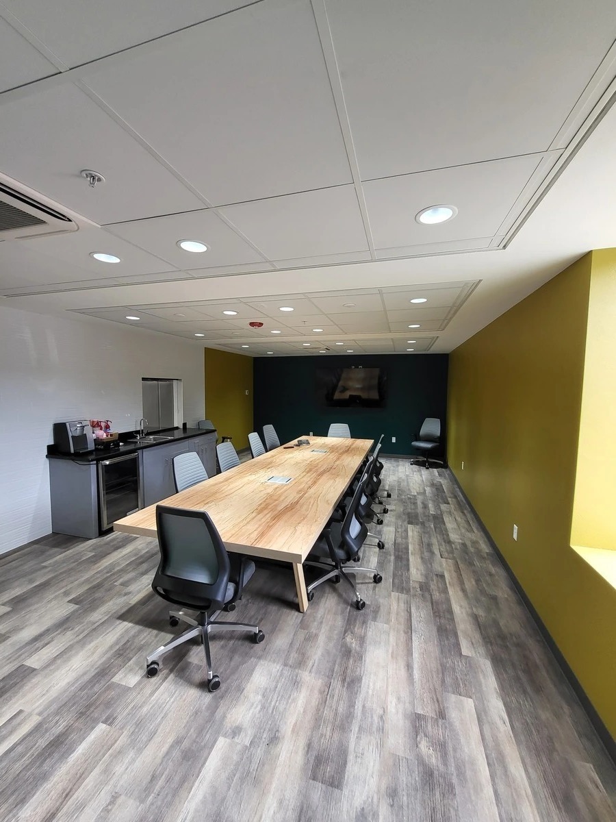 Law firm conference room with long wood table, mesh-back chairs, and coffee bar, Orlando