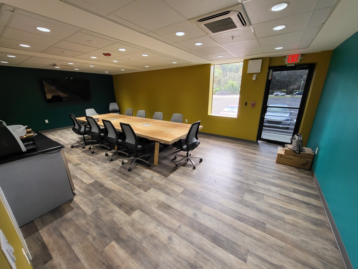 Orlando law firm conference room with wood table, ergonomic task chairs, and wall-mounted display