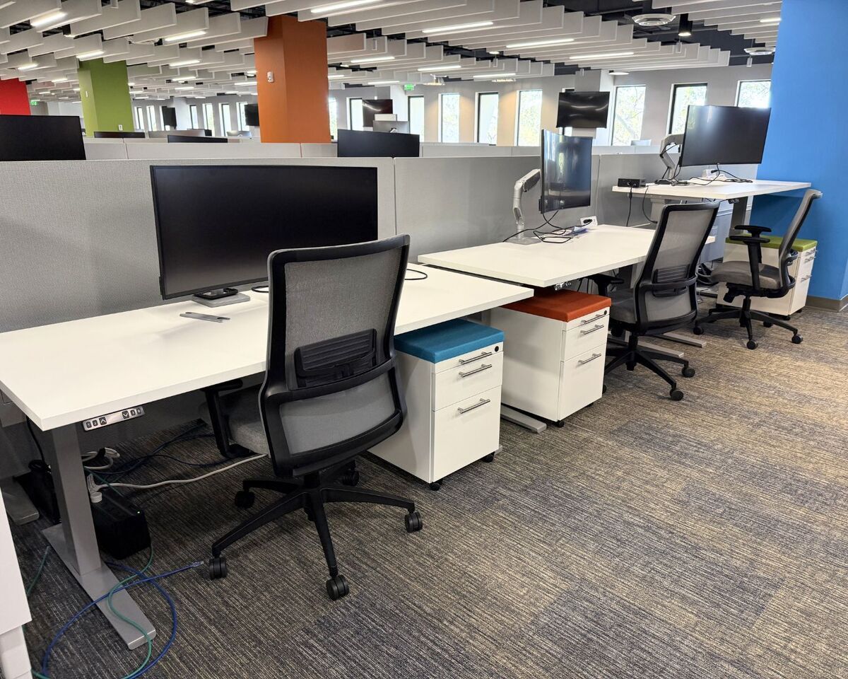 Modern height adjustable office desks, mesh task chairs, and mobile pedestals in an Orlando office furnished with Green Credits