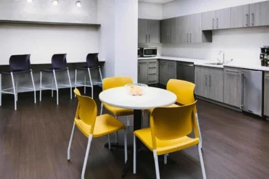 Office break room with yellow chairs, round white table, and bar-height stools, Central Florida