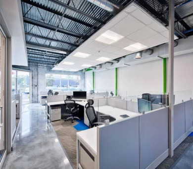 Cubicle workstations with white work surfaces and file pedestals beside polished concrete floors, Orlando