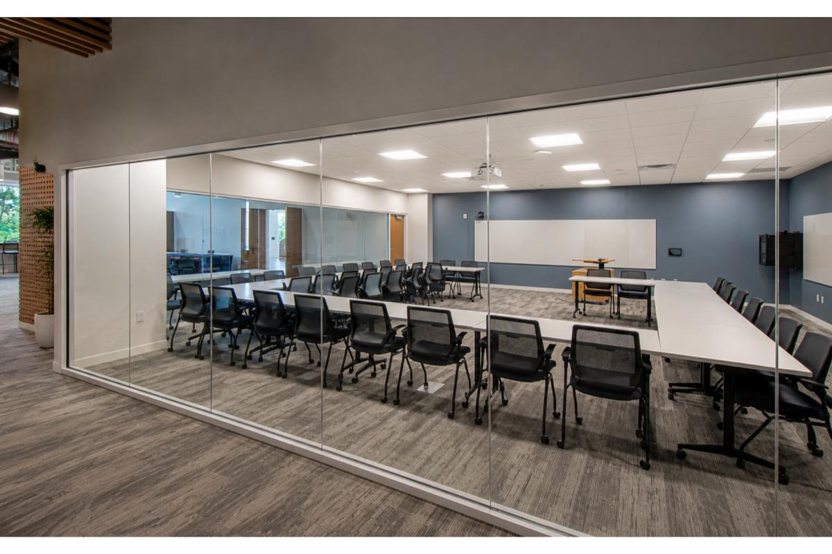 Glass-front training room with long white tables and black mesh chairs, Central Florida