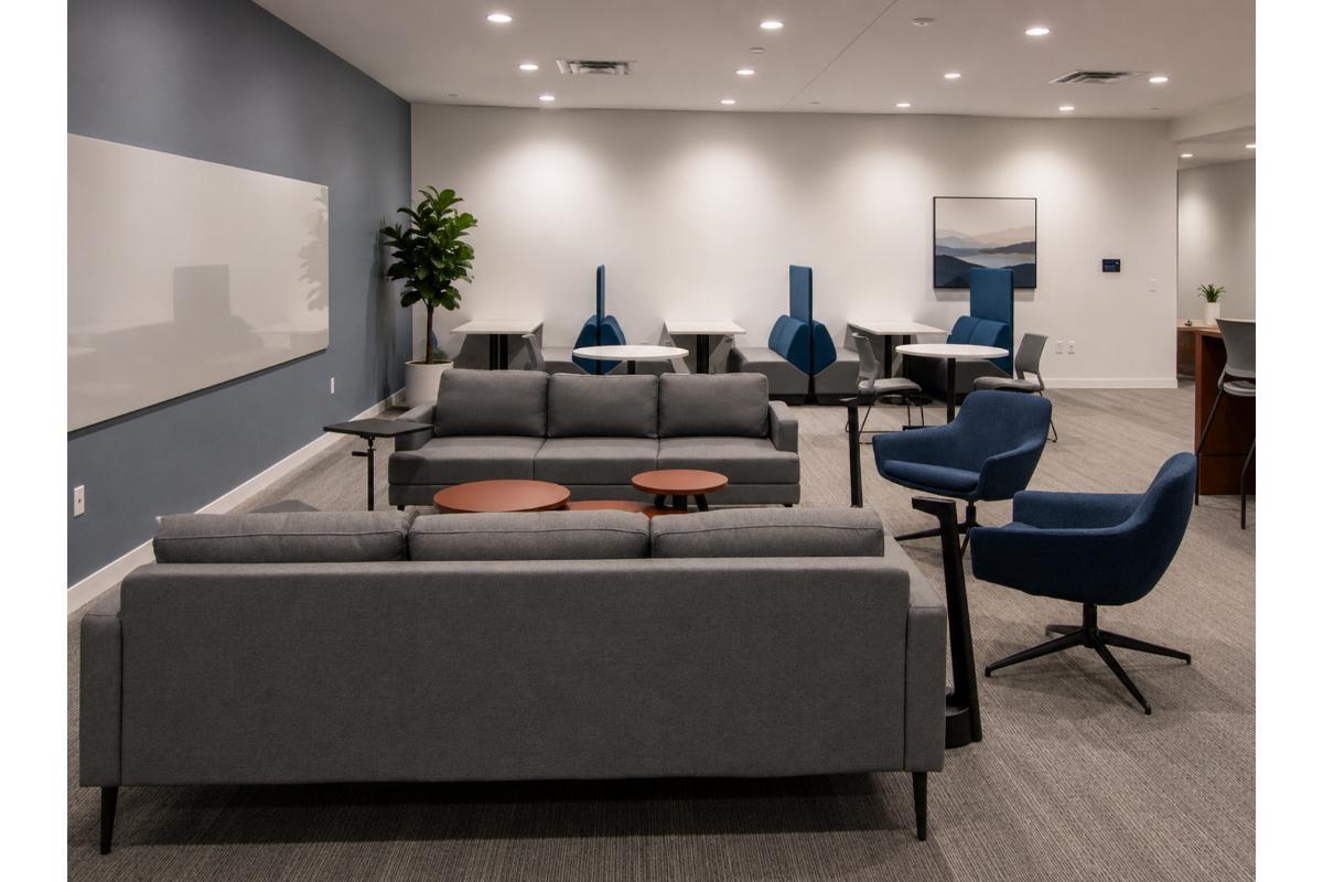 Lounge with gray sofas, navy swivel chairs, and high-back booth seating, Orlando