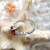bague ajustable en argent 925 avec un magnifique grenat ovale de 6mm x 8mm, accompagné de zircons latéraux