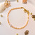 bracelet de perles fines rondes de couleur orange clair avec une perle d'eau douce mini blanche en son centre et un fermoir à ressort Lobster plaqué or.