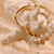 bracelet moitié jonc, moitié perle en plaqué or avec des perles baroques blanches en forme de pomme de terre.