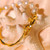 bracelet moitié jonc, moitié perle en plaqué or avec des perles baroques blanches en forme de pomme de terre.