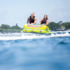 Two riders enjoying the Connelly Fun 2 towable deck tube behind a boat