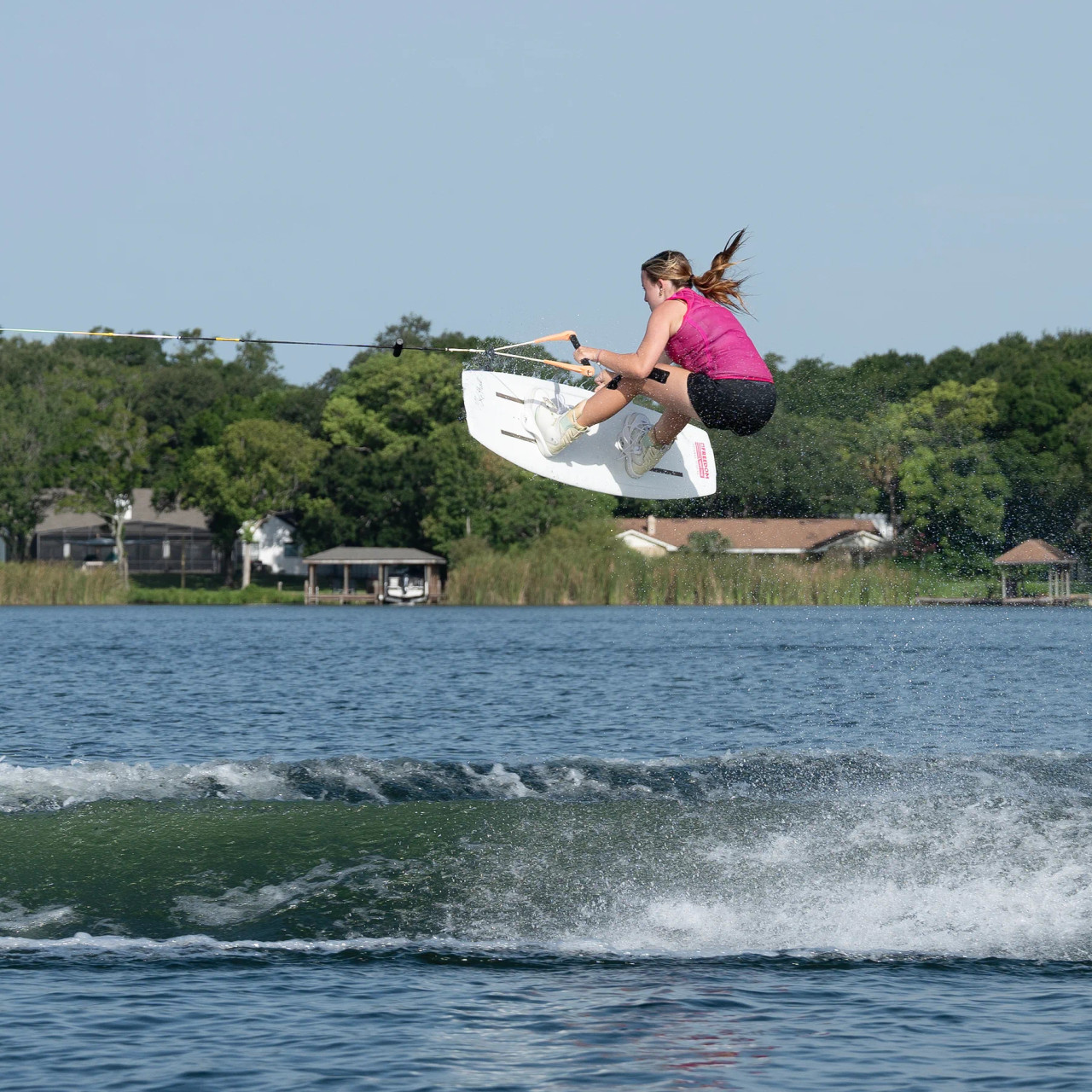 Jetpilot Women’s Wave Farer hot pink vest being worn while wakeboarding Jetpilot Women’s Wave Farer hot pink vest being worn while wakeboarding