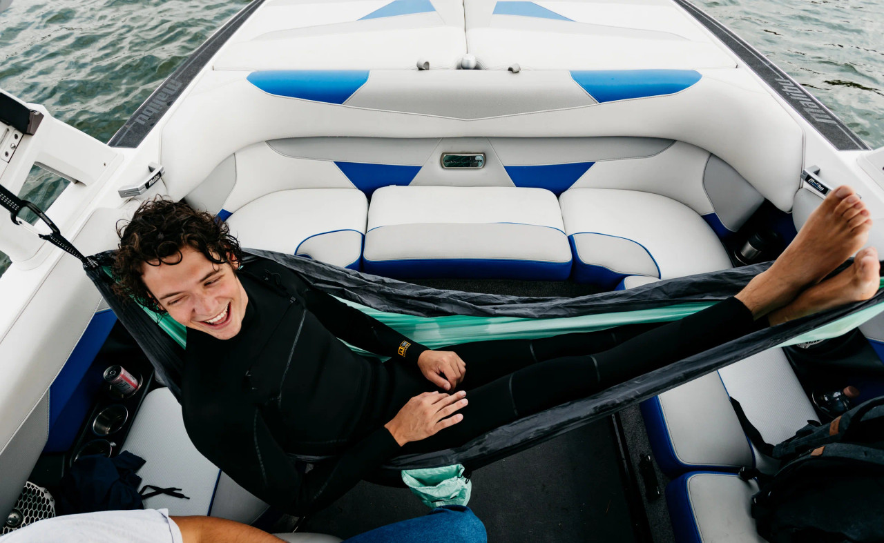 Boat tower hammock installed on wake boat with person relaxing