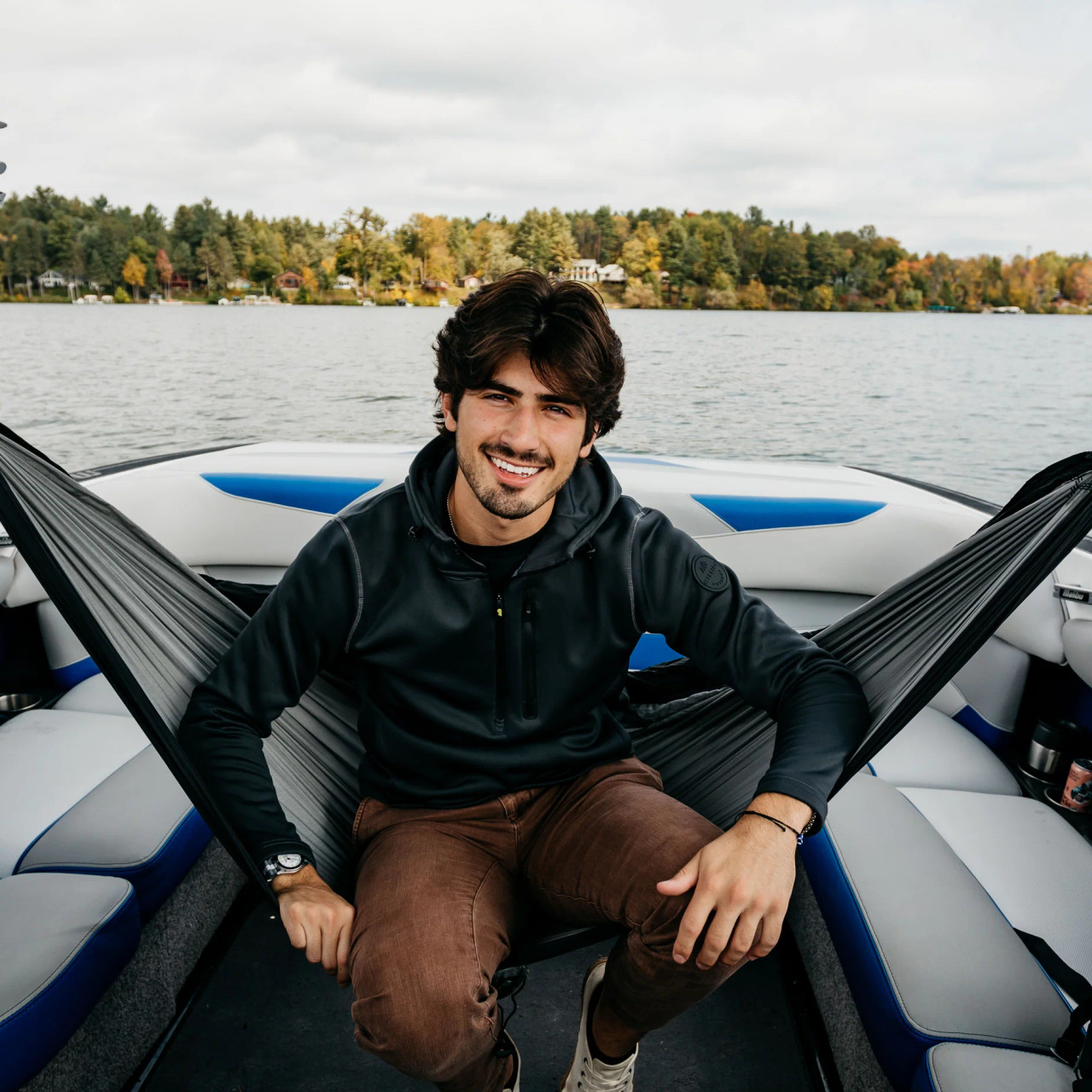 Boat tower hammock installed on wake boat with person relaxing