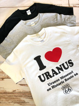 Flat lay of black, gray, and white I Love Uranus novelty t-shirts