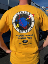 Close-up of the back of a yellow t-shirt with a sci-fi joke logo from Uranus Fudge Factory.