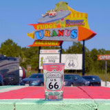 Clear shot glass with a Route 66 design sitting outside at Uranus Fudge Factory.