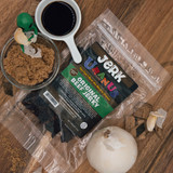 Original flavor beef jerky bag surrounded by small bowls of soy sauce and brown sugar from Uranus Fudge Factory.