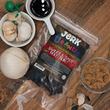 Sweet and spicy beef jerky bag surrounded by fresh onion, garlic, and brown sugar from Uranus Fudge Factory.