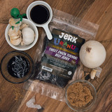 Sweet onion teriyaki beef jerky bag surrounded by culinary ingredients on wood from Uranus Fudge Factory.