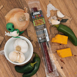 Cheddar and jalapeño beef stick package surrounded by fresh cooking ingredients from Uranus Fudge Factory.
