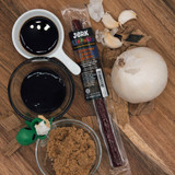 Teriyaki beef stick package surrounded by bowls of soy sauce and brown sugar from Uranus Fudge Factory.
