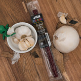 Original flavor beef stick package surrounded by whole garlic cloves and an onion from Uranus Fudge Factory.